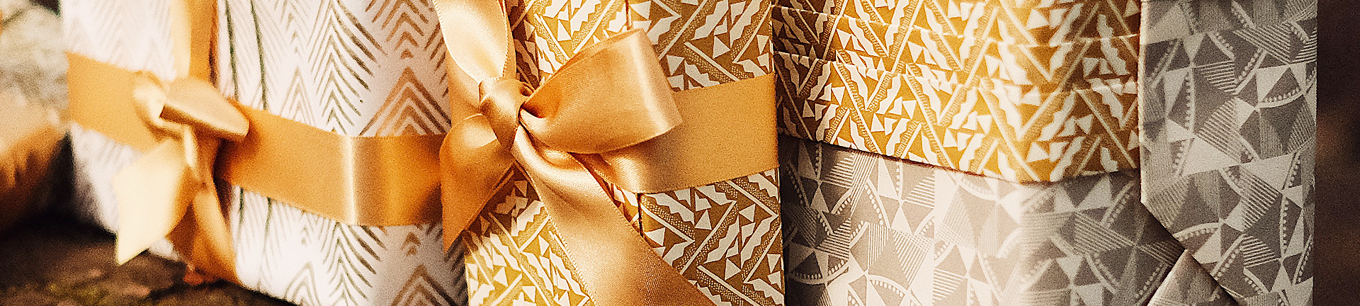 Gold and white gifts professionally wrapped in bow and eco-friendly paper