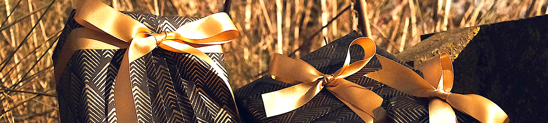 Gifts hand wrapped in black and gold eco-friendly wrapping paper 